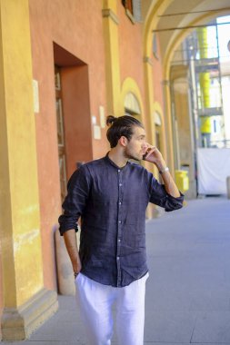 Ortadaki yakışıklı, siyah saçlı adam telefonu kullanıyor. Yüksek kalite fotoğraf