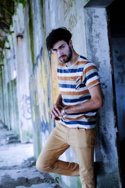 Dejenere olmuş terk edilmiş fabrikadaki yakışıklı siyah saçlı İtalyan adam. Yüksek kalite fotoğraf