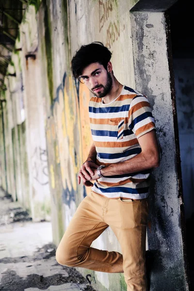 Dejenere olmuş terk edilmiş fabrikadaki yakışıklı siyah saçlı İtalyan adam. Yüksek kalite fotoğraf