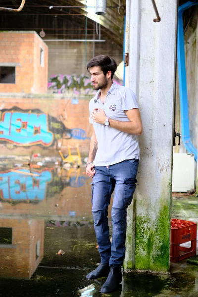 Dejenere olmuş terk edilmiş fabrikadaki yakışıklı siyah saçlı İtalyan adam. Yüksek kalite fotoğraf