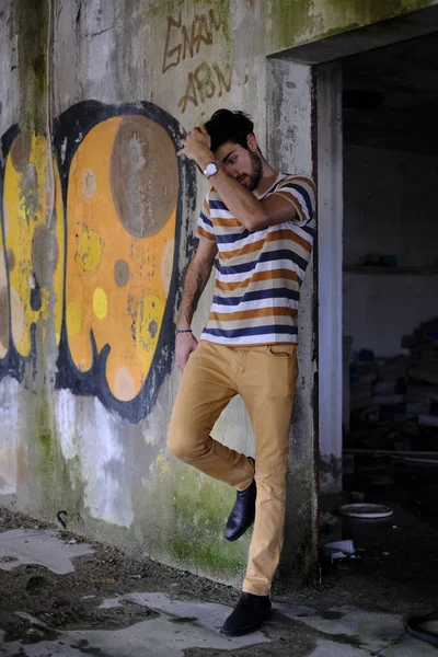 Dejenere olmuş terk edilmiş fabrikadaki yakışıklı siyah saçlı İtalyan adam. Yüksek kalite fotoğraf