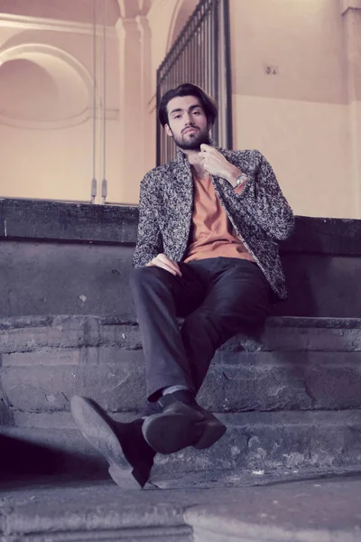 Parma 'daki Pilotta' nın merdivenlerinde oturan yakışıklı siyah saçlı çocuk. Yüksek kalite fotoğraf