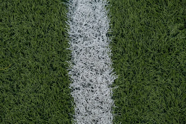 Yeşil sentetik çim spor sahası, yukarıdan beyaz çizgili. Ürün gösterimi, afişi ya da maketi için spor arka planı. Yüksek kalite fotoğraf