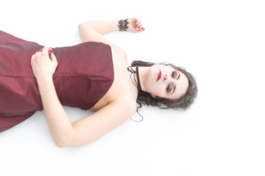 Kana bulanmış kırmızı elbiseli güzel esmer vampir kız karda ölü yatıyor. Yüksek kalite fotoğraf