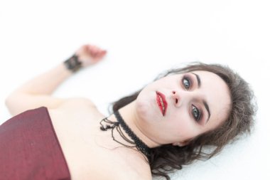 Kana bulanmış kırmızı elbiseli güzel esmer vampir kız karda ölü yatıyor. Yüksek kalite fotoğraf