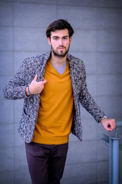 Yakışıklı, siyah saçlı, metal korkuluklara yaslanmış bir çocuk. Yüksek kalite fotoğraf