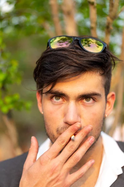 Yakışıklı, siyah saçlı İtalyan çocuk sigara içiyor. Yüksek kalite fotoğraf