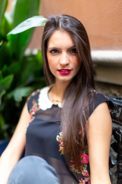 Güzel esmer, İtalyan bir kız bankta oturuyor. Yüksek kalite fotoğraf