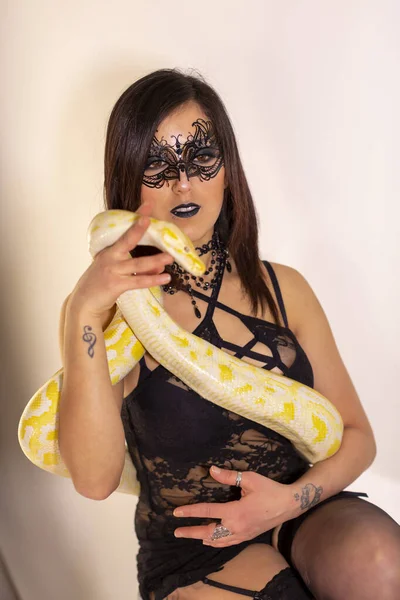 albino molur python with a dark goth brunette girl. High quality photo