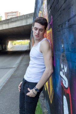 Şehir manzarasında koyu renk saçlı genç bir adam. Yüksek kalite fotoğraf