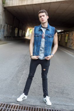 Şehir manzarasında koyu renk saçlı genç bir adam. Yüksek kalite fotoğraf