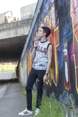 Şehir manzarasında koyu renk saçlı genç bir adam. Yüksek kalite fotoğraf