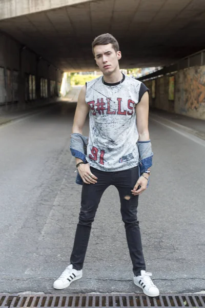 Şehir manzarasında koyu renk saçlı genç bir adam. Yüksek kalite fotoğraf