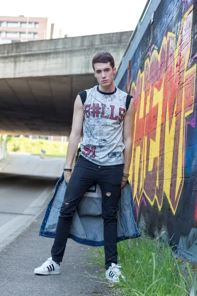 Şehir manzarasında koyu renk saçlı genç bir adam. Yüksek kalite fotoğraf