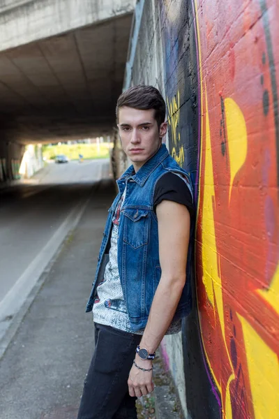 Şehir manzarasında koyu renk saçlı genç bir adam. Yüksek kalite fotoğraf