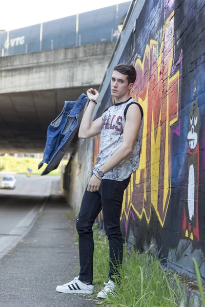 Şehir manzarasında koyu renk saçlı genç bir adam. Yüksek kalite fotoğraf