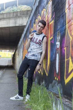 Şehir manzarasında koyu renk saçlı genç bir adam. Yüksek kalite fotoğraf