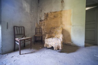 entrance with armchairs and sitting room in old abandoned mansion. High quality photo