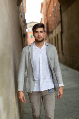 handsome Italian dark-haired guy with elegant jacket in the city center. High quality photo