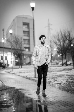 Yakışıklı, koyu renk saçlı İtalyan adam akşam vakti karlı kış parkında yürüyor. Yüksek kalite fotoğraf