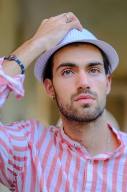 Şehir merkezinde koyu kırmızı tişörtlü yakışıklı, koyu renk saçlı İtalyan adam. Yüksek kalite fotoğraf