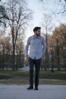 Tişörtlü yakışıklı İtalyan PArma 'daki parkın içinde geziniyor. Yüksek kalite fotoğraf