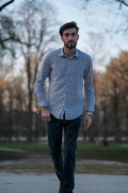 Tişörtlü yakışıklı İtalyan PArma 'daki parkın içinde geziniyor. Yüksek kalite fotoğraf