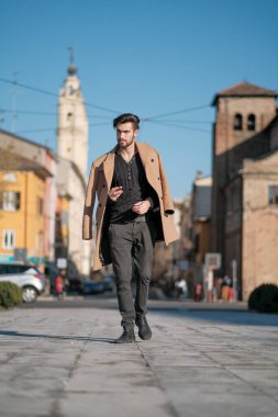 Yakışıklı İtalyan çocuk Parma 'nın tarihi merkezinde paltosuyla yürüyor. Yüksek kalite fotoğraf