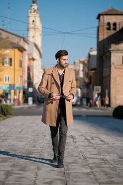 Yakışıklı İtalyan çocuk Parma 'nın tarihi merkezinde paltosuyla yürüyor. Yüksek kalite fotoğraf