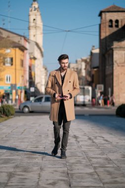 Yakışıklı İtalyan çocuk Parma 'nın tarihi merkezinde paltosuyla yürüyor. Yüksek kalite fotoğraf