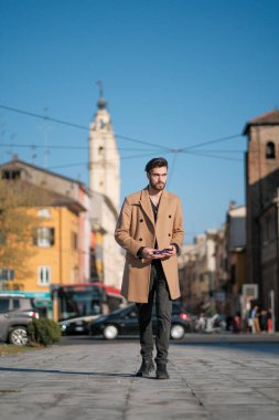 Yakışıklı İtalyan çocuk Parma 'nın tarihi merkezinde paltosuyla yürüyor. Yüksek kalite fotoğraf