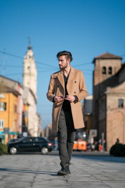 Yakışıklı İtalyan çocuk Parma 'nın tarihi merkezinde paltosuyla yürüyor. Yüksek kalite fotoğraf