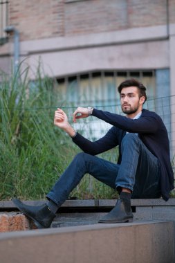 Parma 'daki antik merdivenlerde oturan yakışıklı İtalyan çocuk. Yüksek kalite fotoğraf