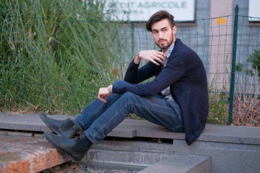 Parma 'daki antik merdivenlerde oturan yakışıklı İtalyan çocuk. Yüksek kalite fotoğraf