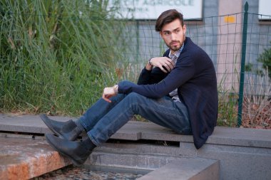 Parma 'daki antik merdivenlerde oturan yakışıklı İtalyan çocuk. Yüksek kalite fotoğraf