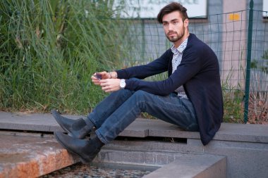 Parma 'daki antik merdivenlerde oturan yakışıklı İtalyan çocuk. Yüksek kalite fotoğraf