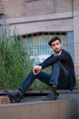 Parma 'daki antik merdivenlerde oturan yakışıklı İtalyan çocuk. Yüksek kalite fotoğraf