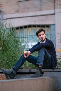 Parma 'daki antik merdivenlerde oturan yakışıklı İtalyan çocuk. Yüksek kalite fotoğraf