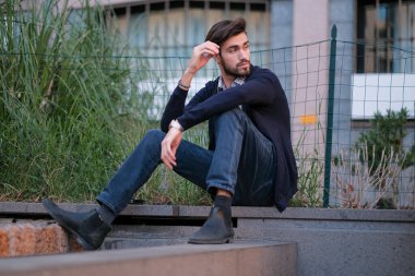 Parma 'daki antik merdivenlerde oturan yakışıklı İtalyan çocuk. Yüksek kalite fotoğraf