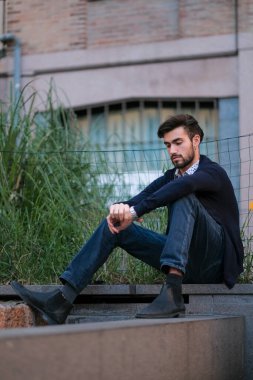 Parma 'daki antik merdivenlerde oturan yakışıklı İtalyan çocuk. Yüksek kalite fotoğraf