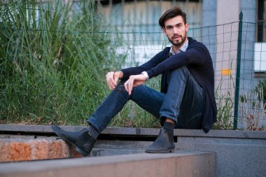 Parma 'daki antik merdivenlerde oturan yakışıklı İtalyan çocuk. Yüksek kalite fotoğraf