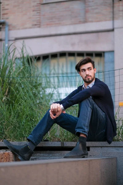 Parma 'daki antik merdivenlerde oturan yakışıklı İtalyan çocuk. Yüksek kalite fotoğraf