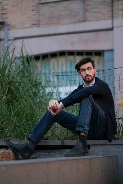 Parma 'daki antik merdivenlerde oturan yakışıklı İtalyan çocuk. Yüksek kalite fotoğraf