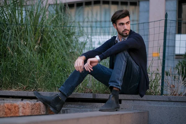 Parma 'daki antik merdivenlerde oturan yakışıklı İtalyan çocuk. Yüksek kalite fotoğraf