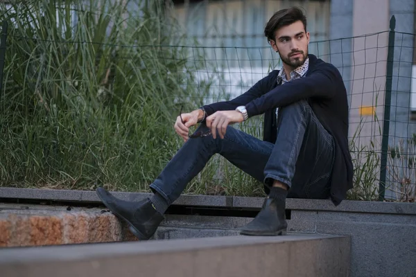 Parma 'daki antik merdivenlerde oturan yakışıklı İtalyan çocuk. Yüksek kalite fotoğraf