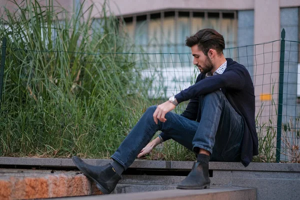 Parma 'daki antik merdivenlerde oturan yakışıklı İtalyan çocuk. Yüksek kalite fotoğraf