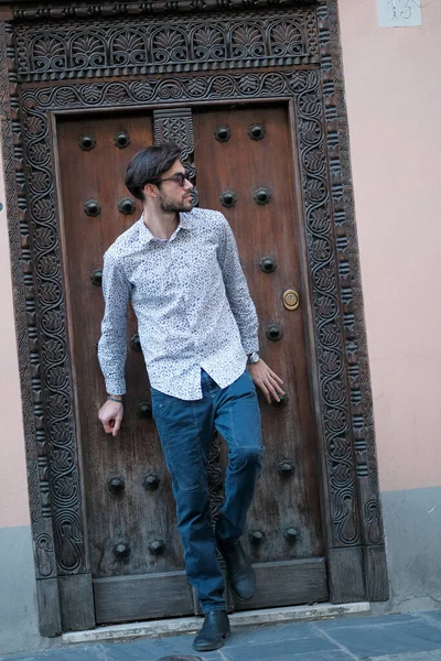 Yakışıklı İtalyan adam eski bir kapının önünde tişörtle poz veriyor. Yüksek kalite fotoğraf