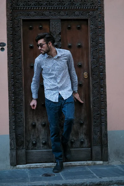 Yakışıklı İtalyan adam eski bir kapının önünde tişörtle poz veriyor. Yüksek kalite fotoğraf