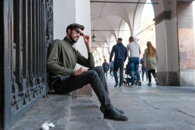 Parma 'daki oyun salonlarının altında oturan yakışıklı İtalyan çocuk. Yüksek kalite fotoğraf