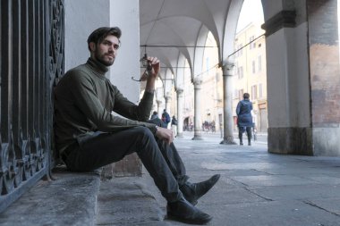 Parma 'daki oyun salonlarının altında oturan yakışıklı İtalyan çocuk. Yüksek kalite fotoğraf